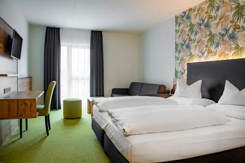 a hotel room with two beds and a desk at Alb Inn - Hotel & Apartments in Merklingen
