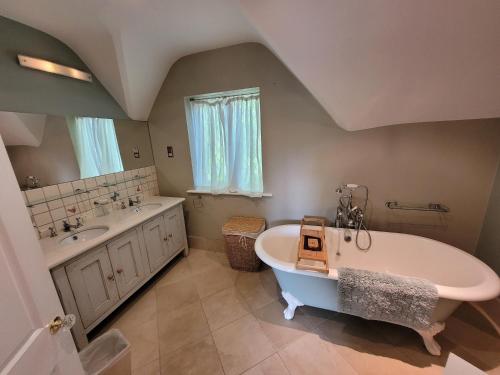 ein Badezimmer mit einer großen Badewanne und einem Waschbecken in der Unterkunft Remarkable 7 Bedroom Family House in Farnborough in Farnborough