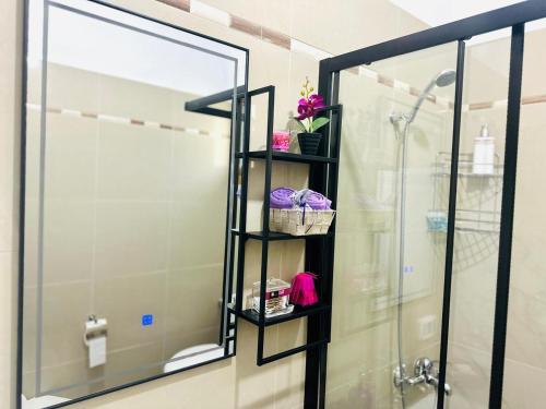 a bathroom with a shower and a shelf with towels at SWEET HOME in Himare
