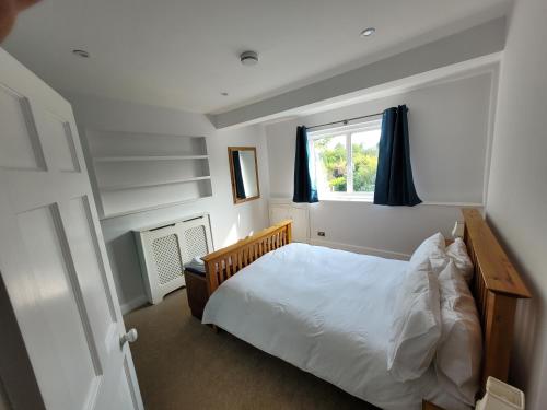 um quarto com uma cama e uma janela em Remarkable 7 Bedroom Family House in Farnborough em Farnborough