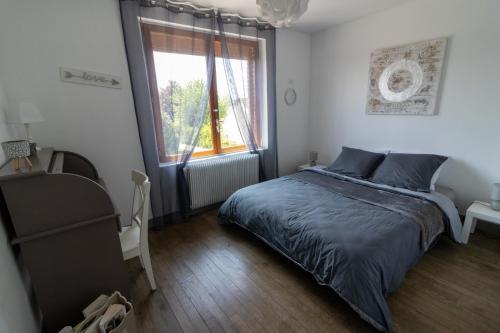 1 dormitorio con cama y ventana en Maison 6 personnes avec jardin et véranda " Les chicoufs ", en Poses