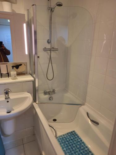 La salle de bains est pourvue d'une douche et d'un lavabo. dans l'établissement WALKING TO TOWER BRIDGE, à Londres