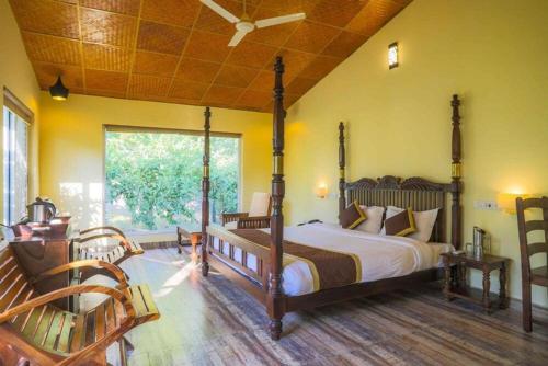 a bedroom with a large bed and a large window at Ranthambore Tiger Inn Comfort Resort in Sawāi Mādhopur