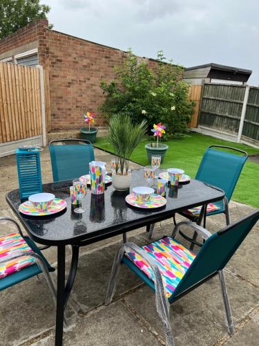 a black table with chairs and plates of food on it at Beautiful 2-bedroom in Grays close to Lakeside in Grays Thurrock