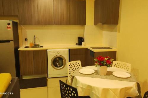 eine Küche mit einem Tisch und einer Waschmaschine in der Unterkunft HA206 - WI-FI- NETFLIX-PARKING- SWIMMING POOL- CYBERJAYa, 3073 in Cyberjaya