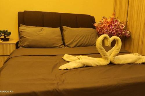 two swans made out of towels on a bed at HA206 - WI-FI- NETFLIX-PARKING- SWIMMING POOL- CYBERJAYa, 3073 in Cyberjaya