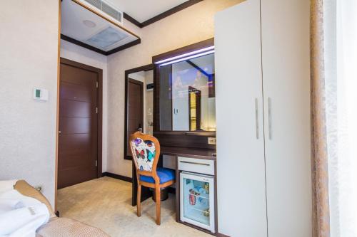 a room with a desk with a chair and a mirror at Taksim Cihangir Fidan Residence Hotel in Istanbul