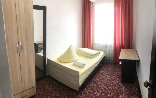 een hotelkamer met een bed en een spiegel bij HalalHostel in Osh