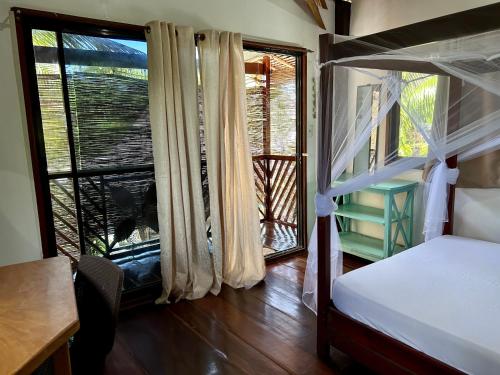 a bedroom with a bed and a view of a balcony at Ilakai Hostel in General Luna