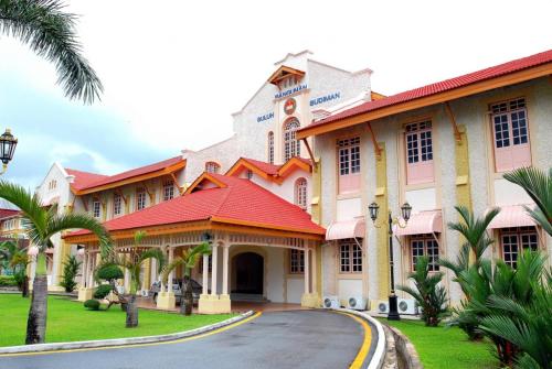 a large building with a red roof and palm trees at Two Bed Rooms -Cahaya Homestay Tanjung Malim in Ulu Bernam