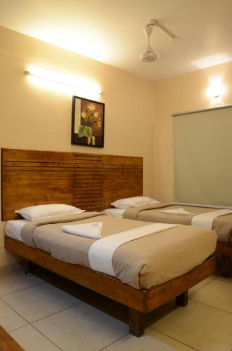 a room with three beds and a chalk board at Hotel Sky Lite in Coimbatore