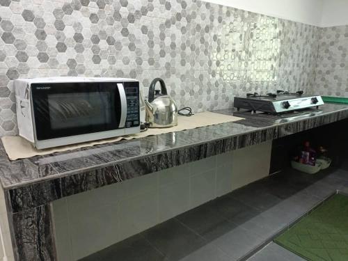 a microwave sitting on a counter in a kitchen at Two Bed Rooms -Cahaya Homestay Tanjung Malim in Ulu Bernam