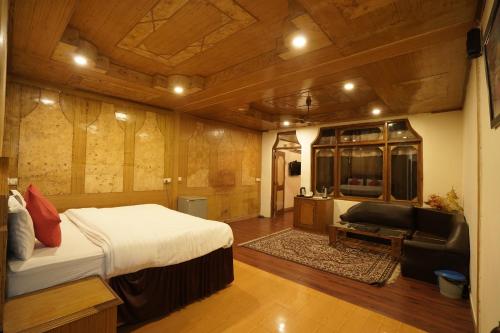 1 dormitorio con cama, sofá y TV en Royal Palace Resort Bhagsunag, en Dharamshala