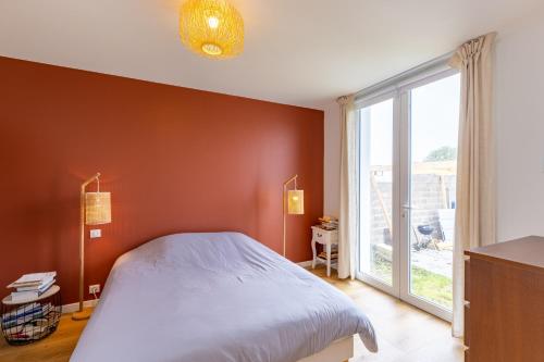 une chambre avec un lit et une grande fenêtre dans l'établissement Maison de bord de mer avec jardin, à Les Sables-dʼOlonne