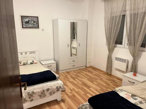 a bedroom with two beds and a mirror at Apartman na rijeci Cijevni in Podgorica