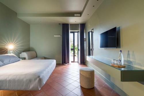 a hotel room with a bed and a tv at Nèroli Bio Relais in Catania