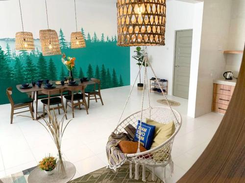 a living room with a swinging chair and a table at ForestNest Cameron Town Spacious 3R3B (1300 sqft) in Tanah Rata