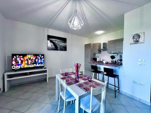 kuchnia z białym stołem i krzesłami oraz telewizorem w obiekcie Appartamento Ortona Vista Mare w mieście Francavilla al Mare