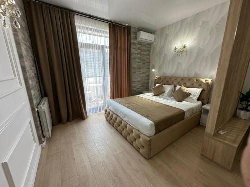 a bedroom with a bed and a large window at Moonlight Apart-Hotel Batumi in Batumi