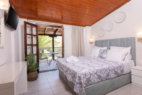 a bedroom with a bed and a balcony at Hotel Magdalena in Pefkohori