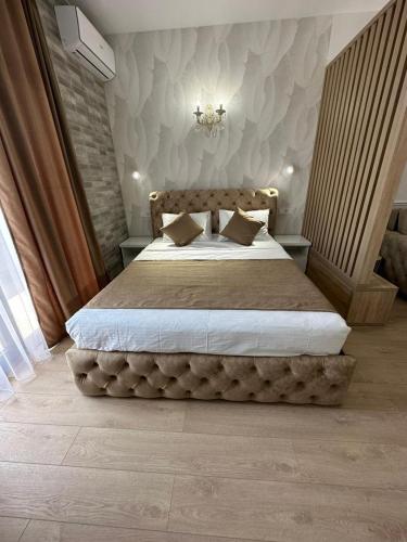 a bedroom with a large bed with a tufted headboard at Moonlight Apart-Hotel Batumi in Batumi