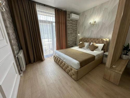 a bedroom with a bed and a large window at Moonlight Apart-Hotel Batumi in Batumi