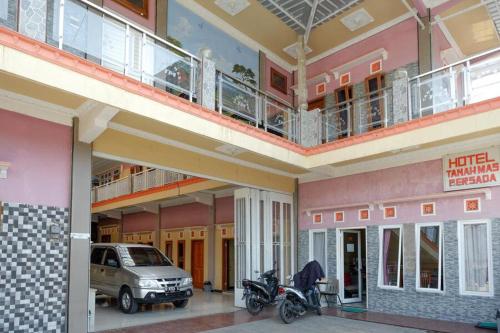 a large building with a car parked inside of it at RedDoorz near Desa Wisata Tambi Dieng in Wonosobo