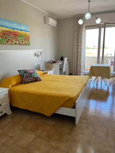 a bedroom with a large bed with a yellow blanket at Le Stanze di Lucia vicino Ospedale Cardinale Panico a Tricase in Tricase