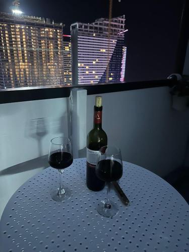 a bottle of wine sitting on a table with two glasses at Moonlight Apart-Hotel Batumi in Batumi