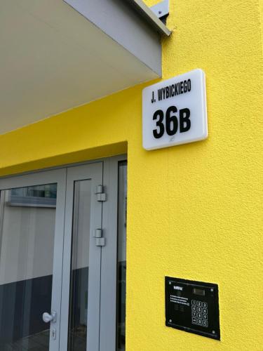 a sign on the side of a yellow building at Apartament Elle in Malbork
