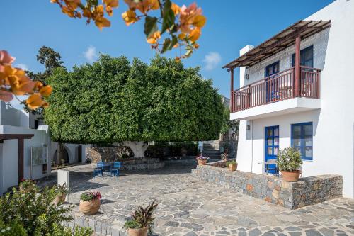 a villa with a large tree in front of a building at Creta Maris Resort in Hersonissos