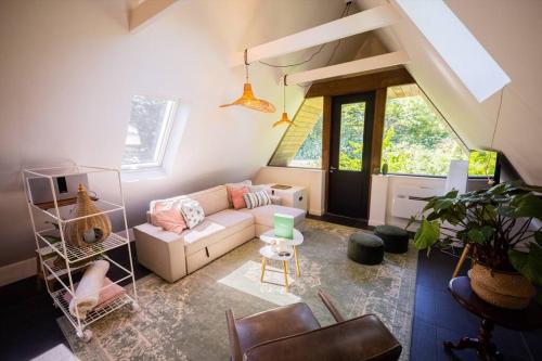 a living room with a couch and a window at Wonderful 50m2 Loft Eindhoven - KS8 in Eindhoven