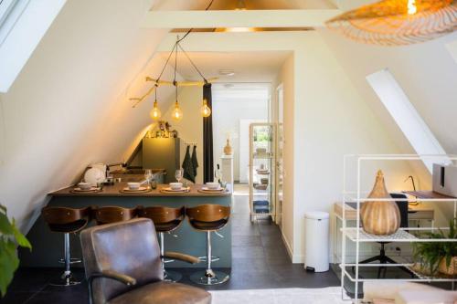 a bar in the middle of a room with chairs at Wonderful 50m2 Loft Eindhoven - KS8 in Eindhoven
