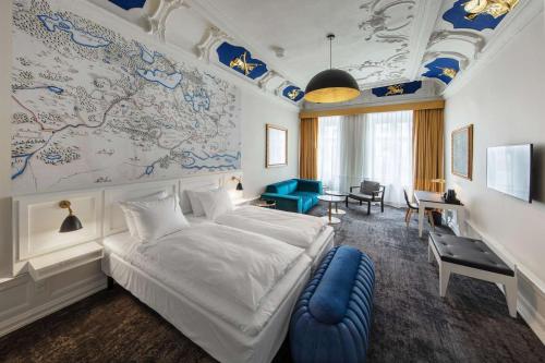 Jørgensens Hotel في هورسنز: غرفة نوم بسرير ابيض كبير وكرسي ازرق