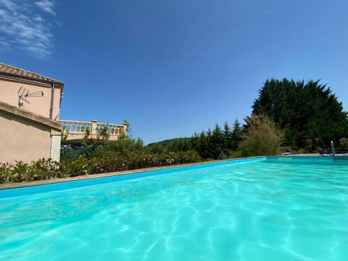 une grande piscine devant une maison dans l'établissement Avantime, à La Bachellerie