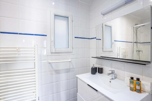 une salle de bain blanche avec un lavabo et un miroir dans l'établissement 20 - Urban Design Flat Pere Lachaise, à Paris