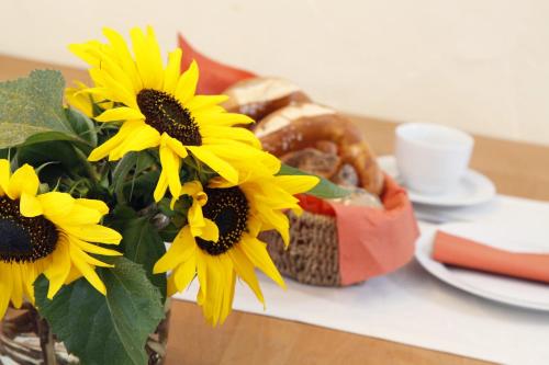 a vase filled with yellow sunflowers on a table at Ferienwohnungen Holder in Anhausen
