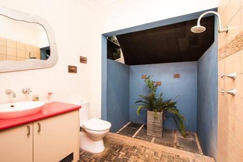 uma casa de banho com um WC, um lavatório e um espelho. em Asrama Broome em Broome