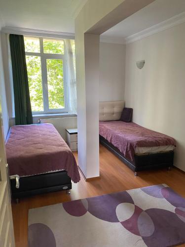 1 Schlafzimmer mit 2 Betten und einem Teppich in der Unterkunft kireçburnu mahallesinde deniz manzaralı eşyalı daire in Istanbul