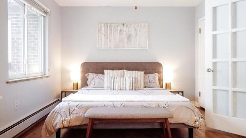 um quarto com uma cama grande e 2 janelas em Family-Friendly Mid-century Modern Retreat em Denver