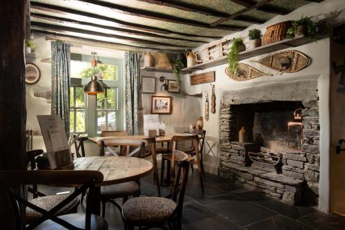 a dining room with a fireplace and tables and chairs at Wateredge Inn- The Inn Collection Group in Ambleside