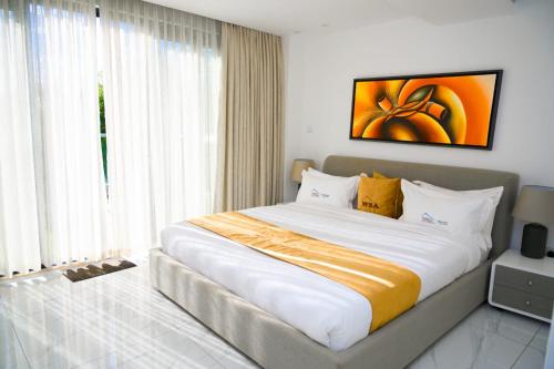 uma cama grande num quarto com uma janela grande em White Stone Apartments Nyarutarama em Kigali