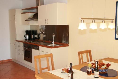 a kitchen with a table and a sink and a stove at Ferienwohnungen Holder in Anhausen