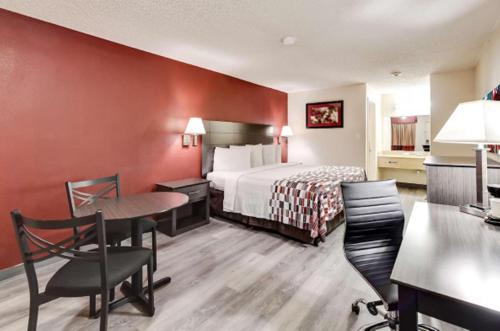 um quarto de hotel com uma cama, uma mesa e cadeiras em American Inn em Corsicana