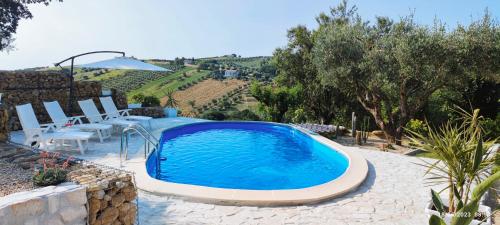 una piscina en medio de un patio con mesa y sillas en Casa Sergio, en Colonnella