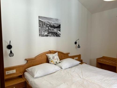 uma cama num quarto com uma fotografia na parede em Haus Silent Apartment TOBI TOP 27 em Schladming