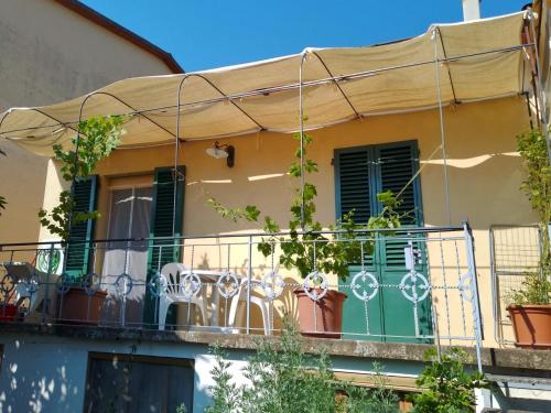 una casa con balcone con persiane verdi di La Casina dei nipoti a Strada