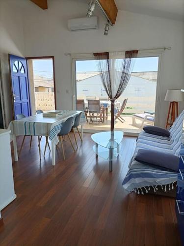 un salon avec un canapé bleu et une table dans l'établissement Chalet La Mer Veille 1, à Gruissan