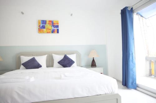 a bedroom with a white bed and a window at Aloft Hotel and Hostel Pattaya in Nong Prue