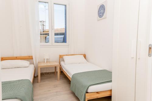 2 camas en una habitación pequeña con ventana en Villa Malta, en Duna Verde